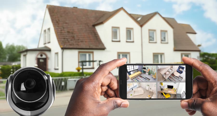 Man holding smartphone and looking at streams from surveillance cameras